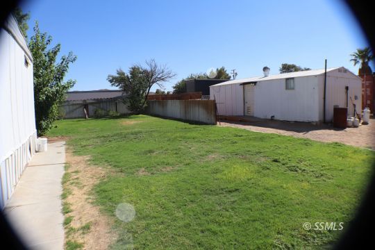 1241 South Mahan Street Ridgecrest, CA 93555 - Photo 17 of 28 a backyard of a house with plants and a tree