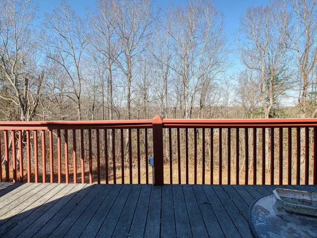 a balcony with wooden floor and fence