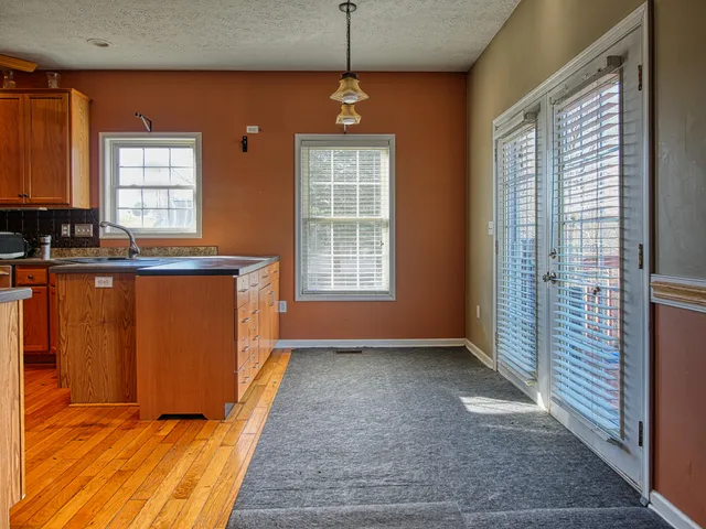 a view of a kitchen with wooden floor and a window