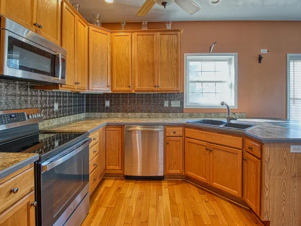 a kitchen with granite countertop a sink stove and cabinets
