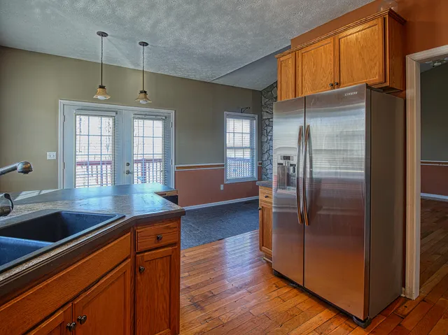 a kitchen with stainless steel appliances granite countertop a refrigerator a sink and a stove