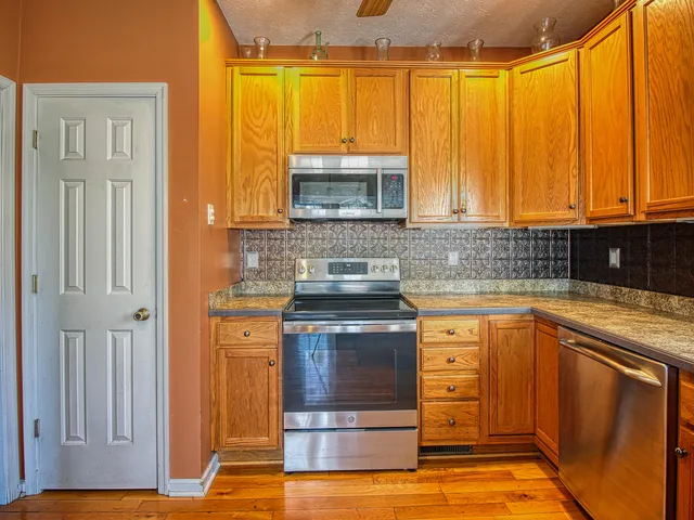 a kitchen with stainless steel appliances granite countertop a stove a sink and a microwave