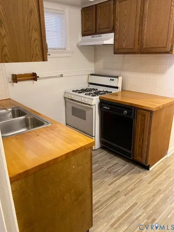 a kitchen with stainless steel appliances a stove a sink and a microwave