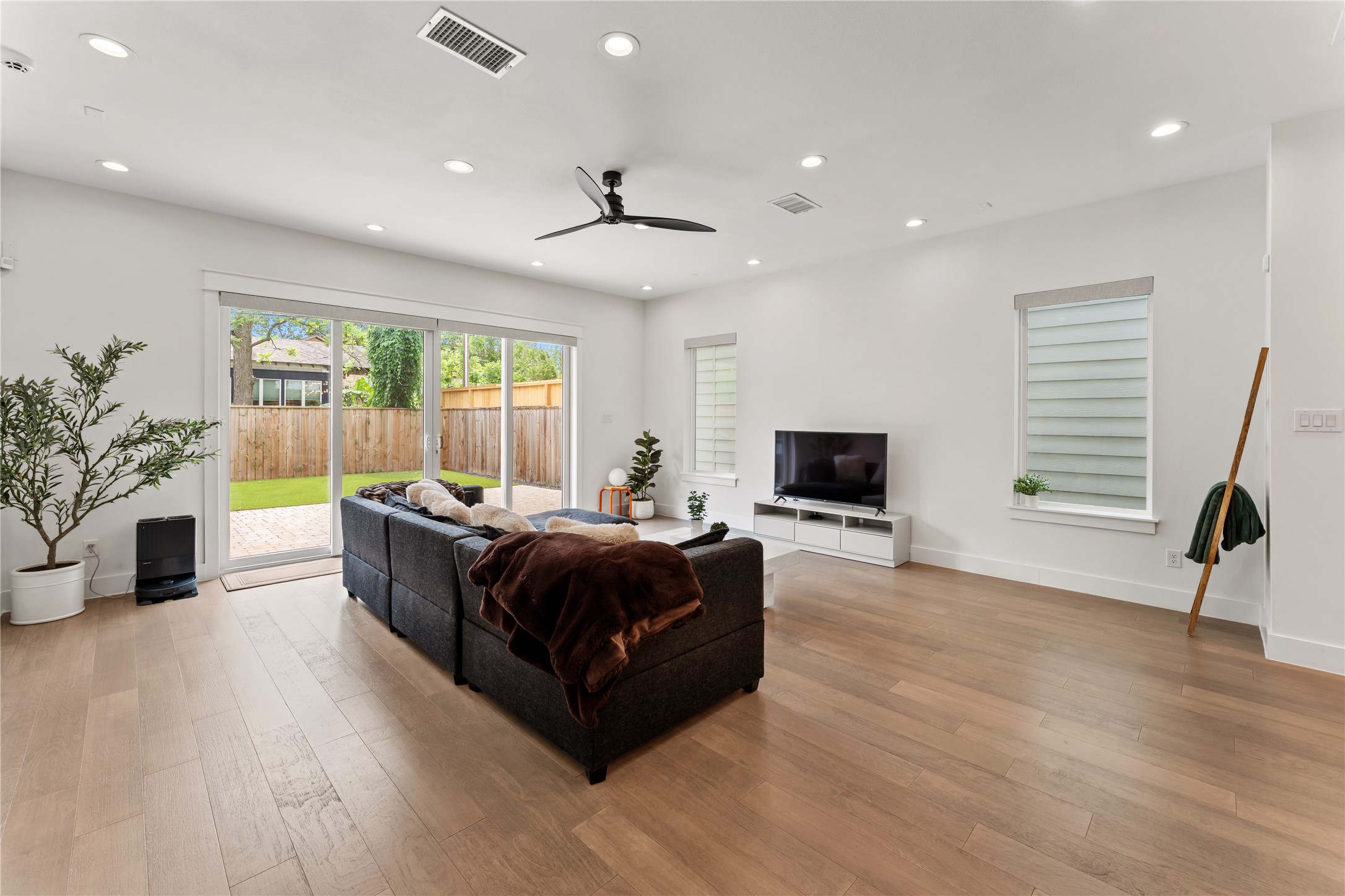 820 East 24th Street Houston, TX 77009 - Photo 12 of 34 The living area offers a comfortable yet refined space to unwind. Large windows and backyard views create a bright, airy atmosphere. This space flows seamlessly to the outdoors for true indoor-outdoor living.