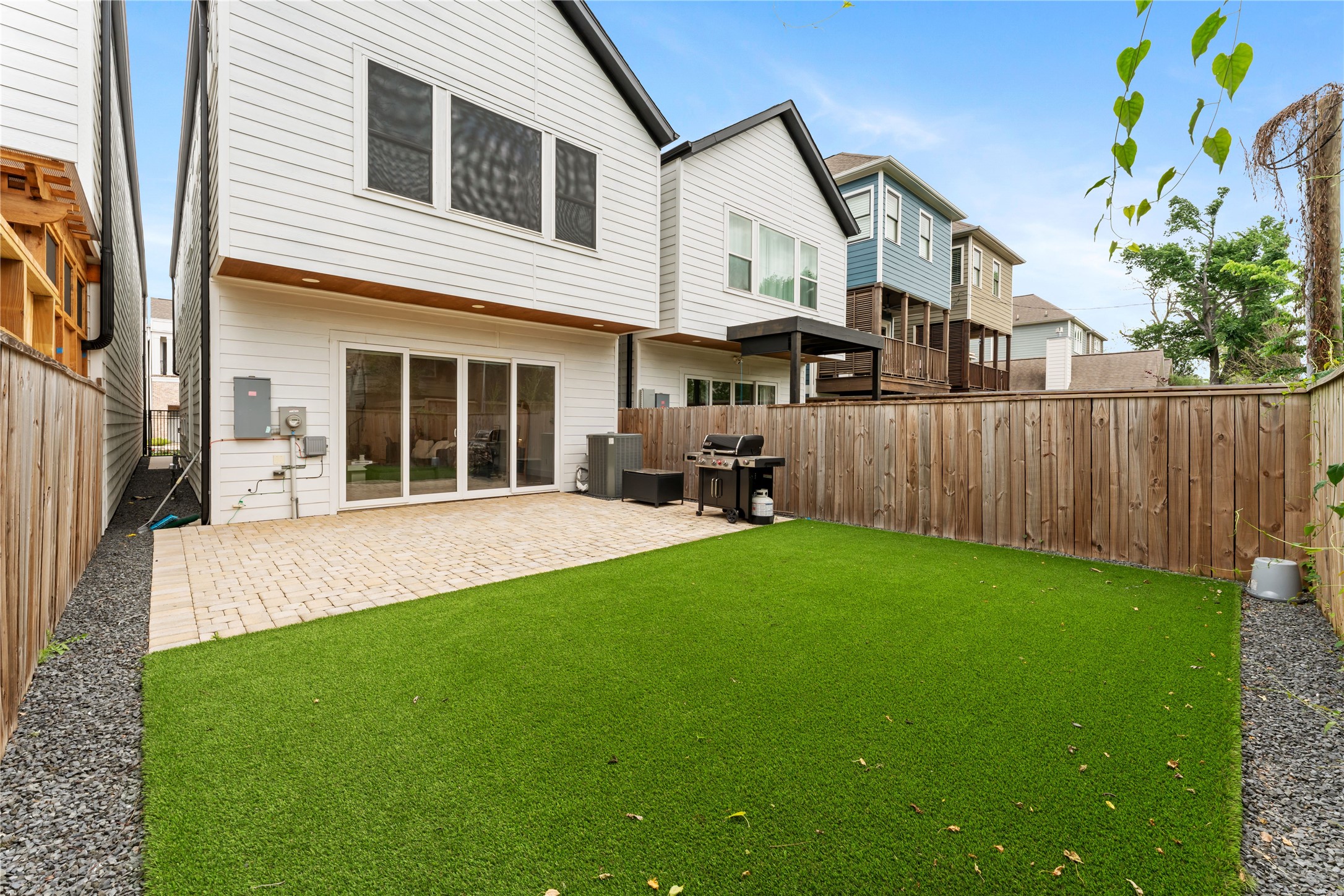 820 East 24th Street Houston, TX 77009 - Photo 31 of 34 Enjoy seamless indoor-outdoor living with direct access to this beautifully designed backyard space. The combination of green turf and a spacious patio creates a balanced setting for recreation and entertaining. Clean lines and easy upkeep make this outdoor area both stylish and functional.