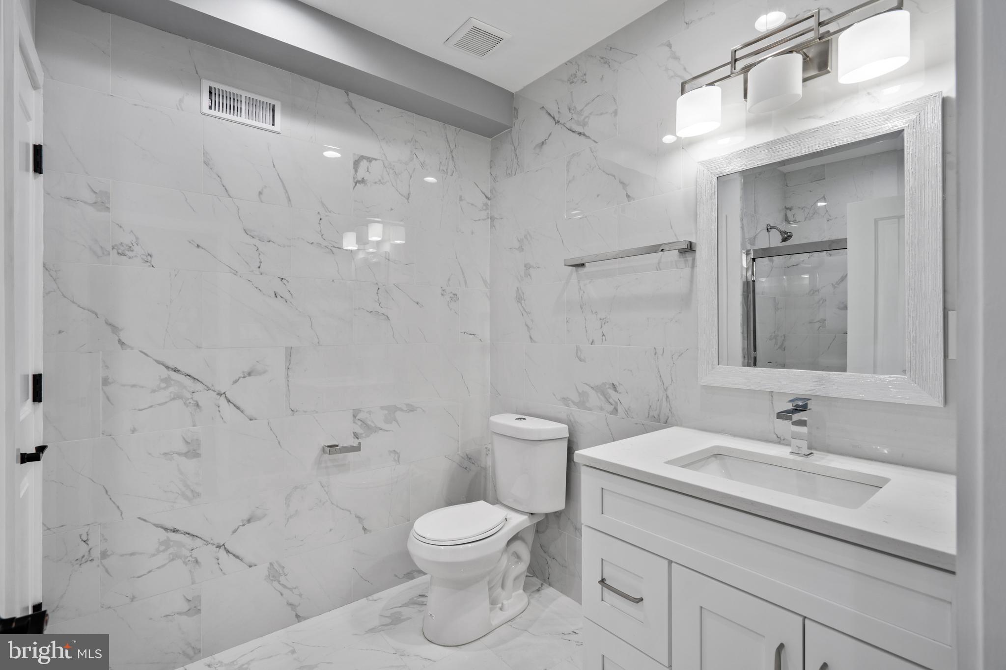 1605 Manton Street Philadelphia, PA 19146 - Photo 7 of 21 a bathroom with a granite countertop sink a toilet and shower