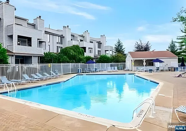 a view of swimming pool with outdoor seating and house in the background