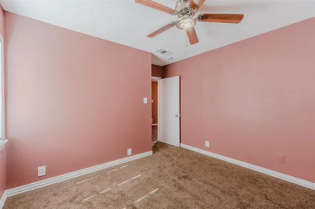 an empty room with a fan and a fan