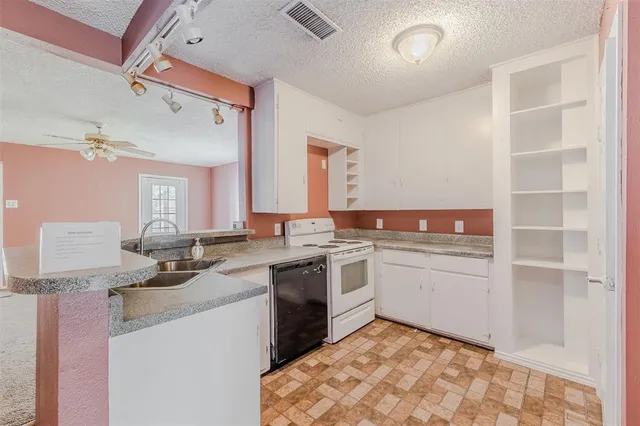 a kitchen with a sink cabinets and wooden floor