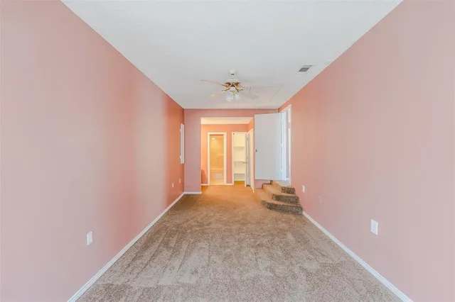 an empty room with a window and a ceiling fan