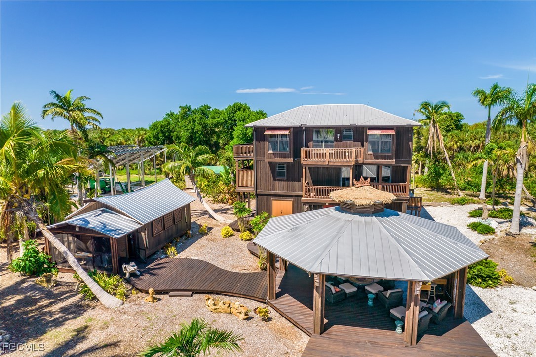 1000 Cayo Costa Boca Grande, FL 33921 - Photo 21 of 47 a view of a patio with table and chairs potted plants with wooden floor and floor to ceiling window