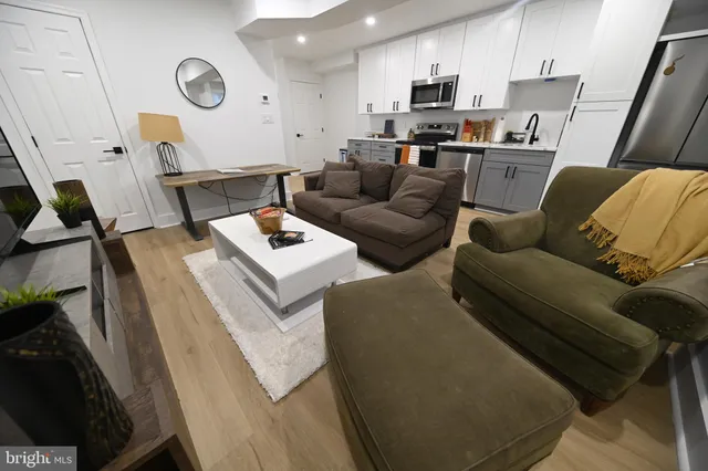 a living room with furniture and a wooden floor