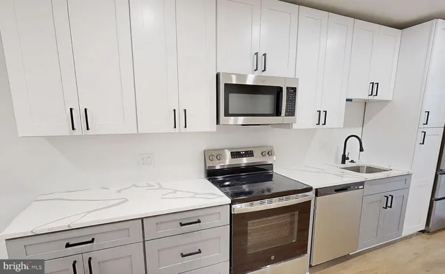 a kitchen with stainless steel appliances granite countertop white cabinets a sink and dishwasher