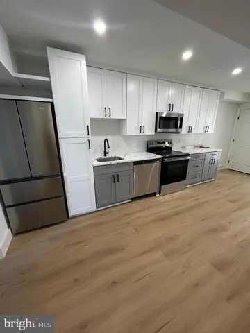 a large kitchen with a stove a sink and a refrigerator