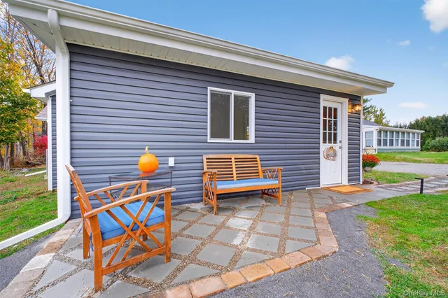 a backyard of a house with barbeque oven table and chairs