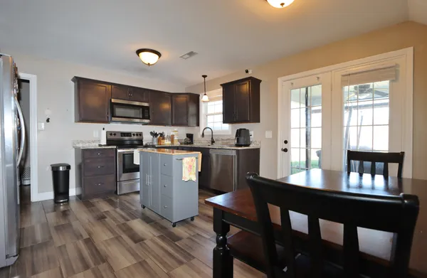 a kitchen with a table chairs refrigerator and microwave
