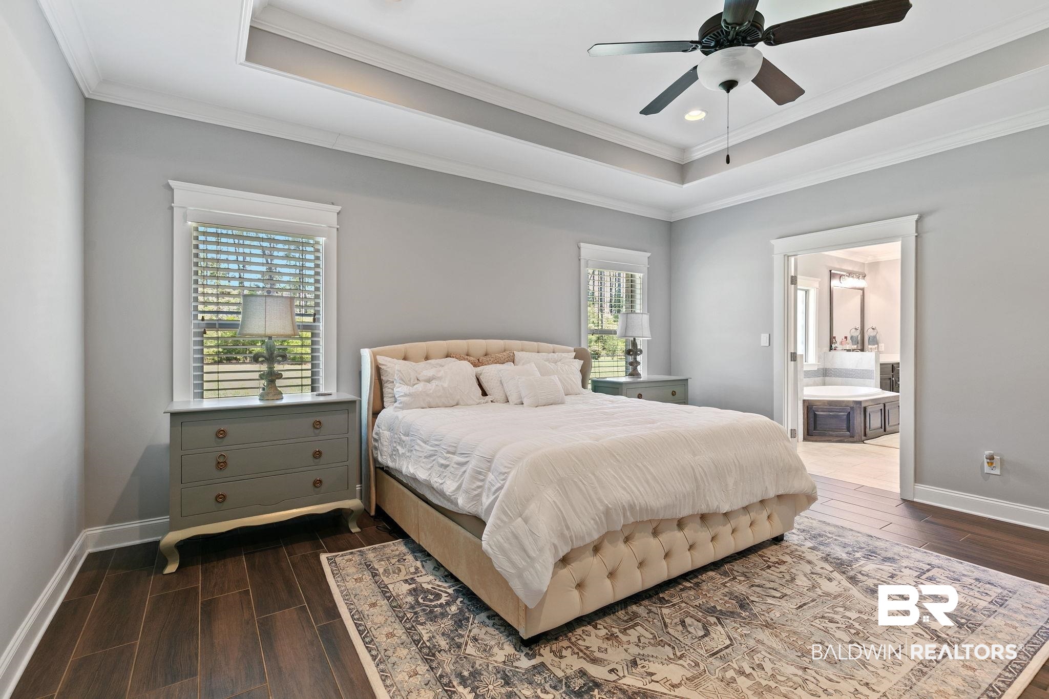 31911 Bobwhite Road Daphne, AL 36527 - Photo 28 of 85 Bedroom featuring wood tiled floors, ensuite bath, a raised ceiling, crown molding, and ceiling fan