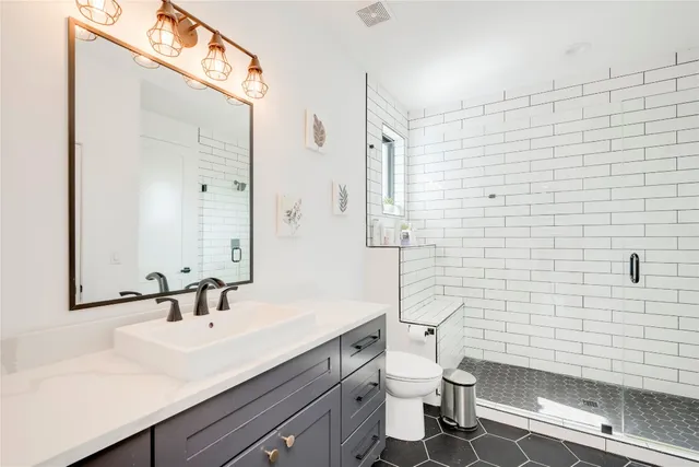 a bathroom with a sink a toilet and shower