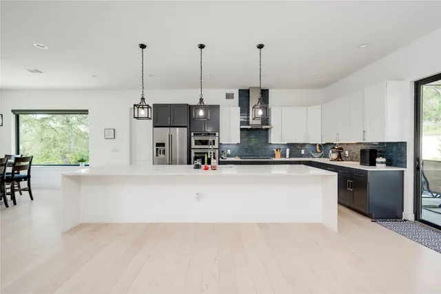 a kitchen with kitchen island a large counter top appliances and cabinets