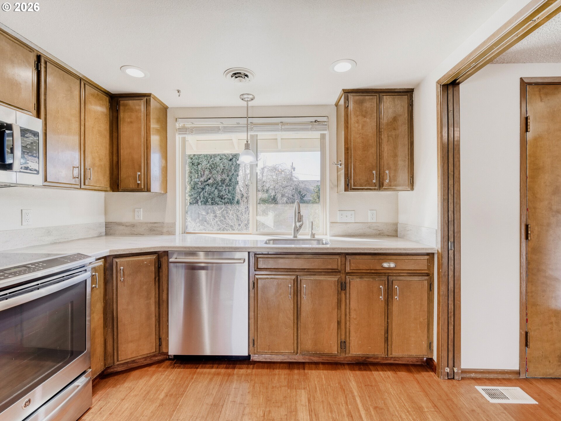 16588 Southwest Matador Lane Portland, OR 97224 - Photo 14 of 28 a kitchen with stainless steel appliances granite countertop a sink and wooden cabinets