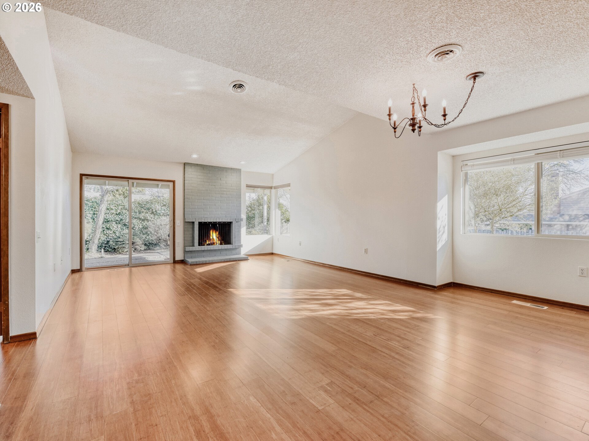 16588 Southwest Matador Lane Portland, OR 97224 - Photo 6 of 28 an empty room with wooden floor chandelier and windows