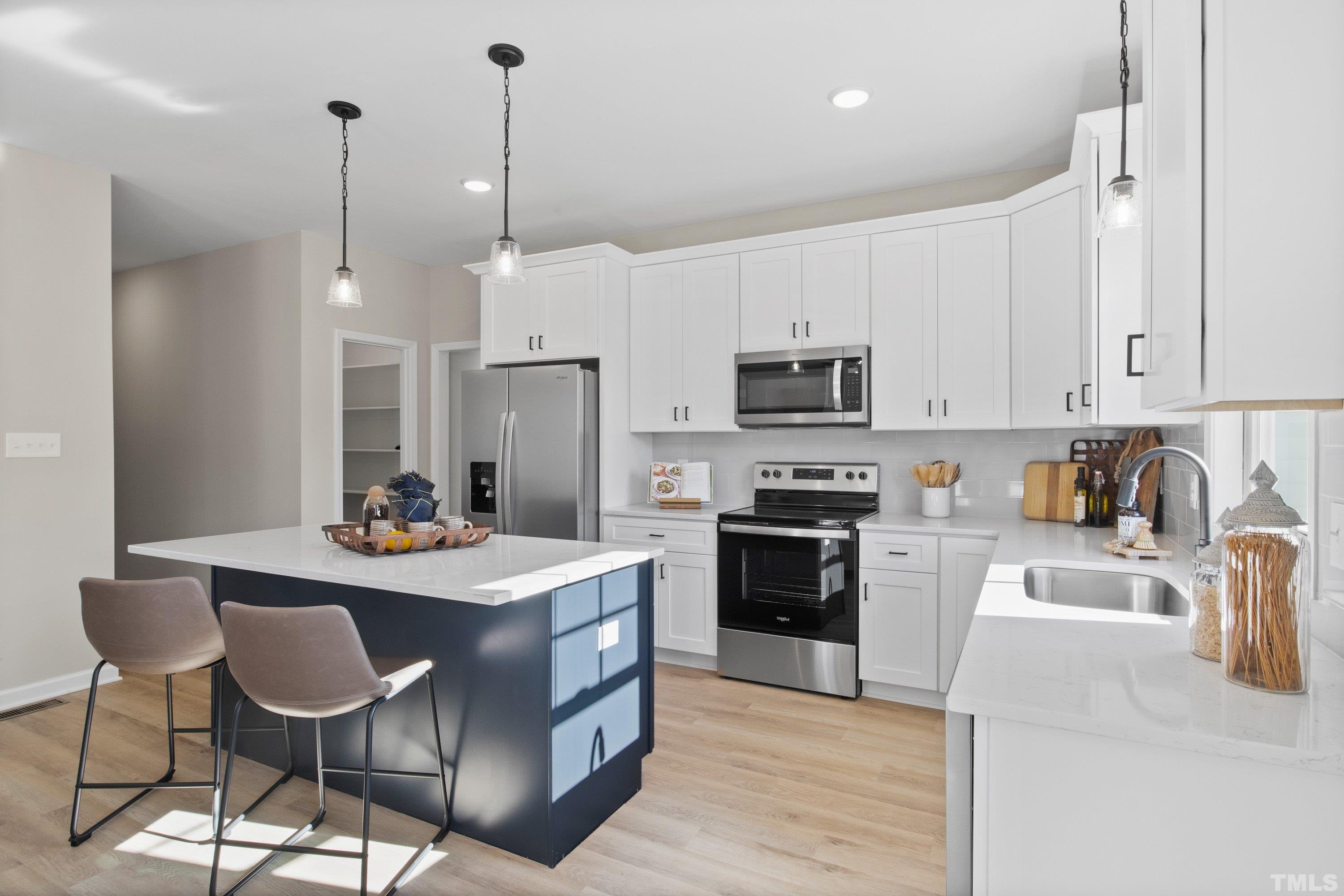 9765 Bear Run Lane Middlesex, NC 27557 - Photo 16 of 38 a kitchen with kitchen island granite countertop a stove a sink a dining table and chairs