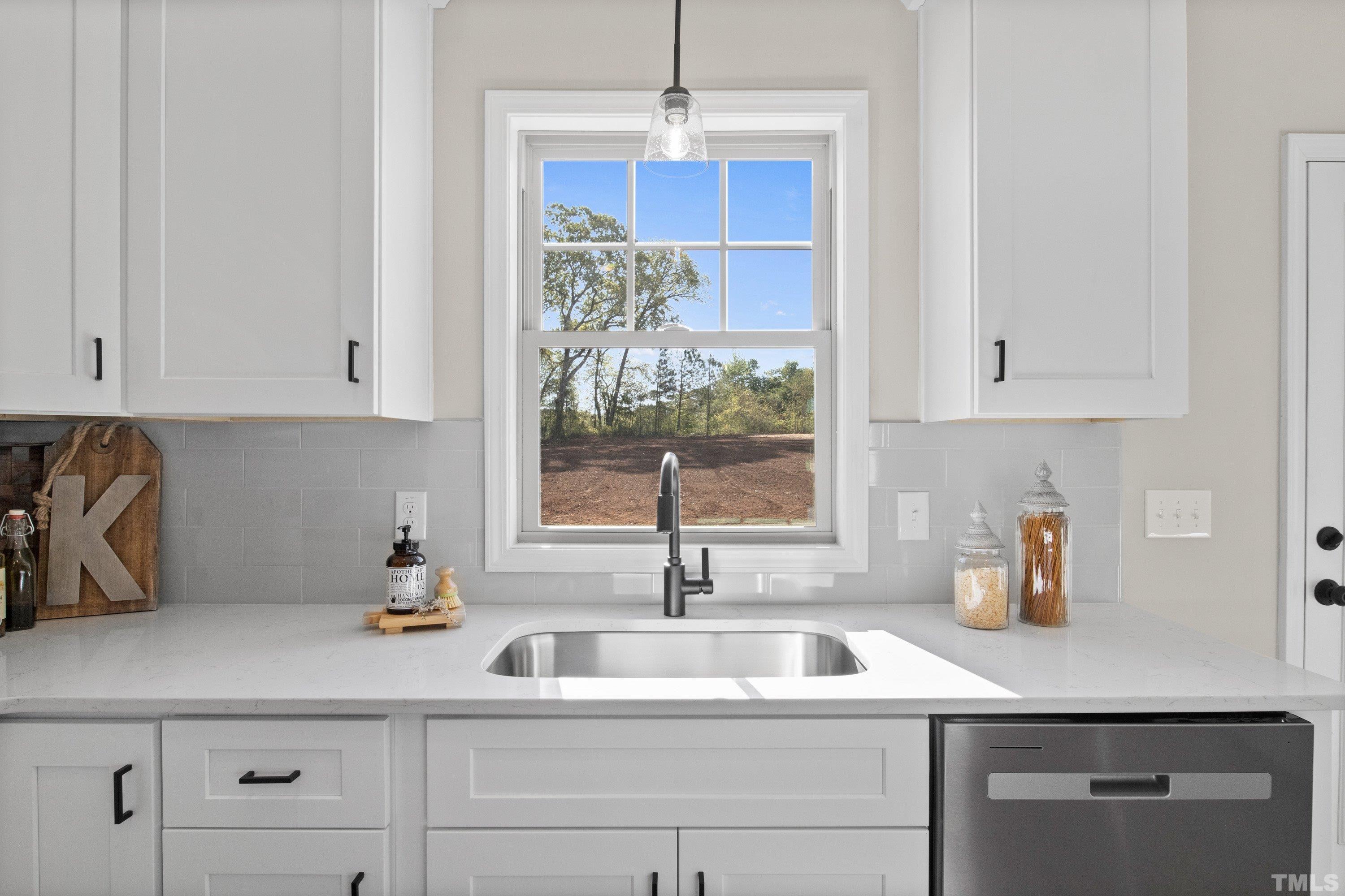9765 Bear Run Lane Middlesex, NC 27557 - Photo 18 of 38 a kitchen with stainless steel appliances a sink a window and white cabinets
