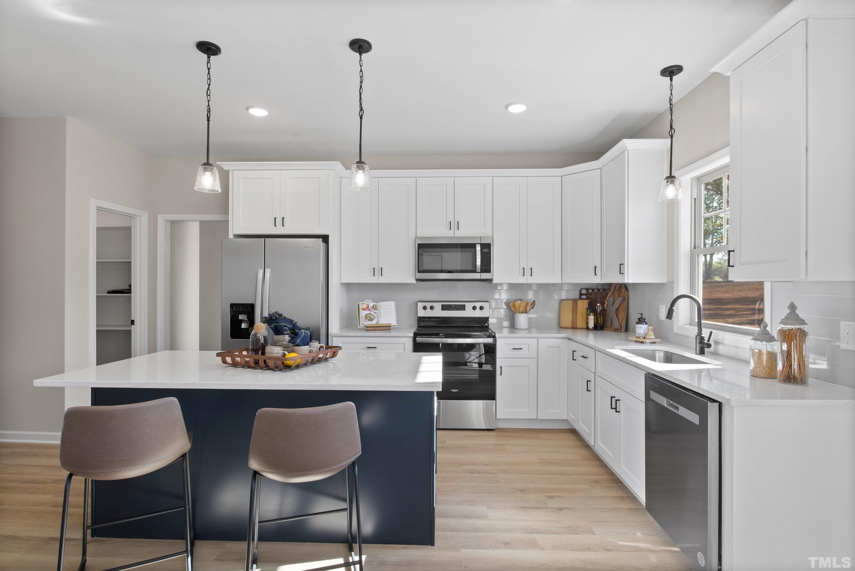 9765 Bear Run Lane Middlesex, NC 27557 - Photo 3 of 38 a kitchen with stainless steel appliances granite countertop a sink a stove a refrigerator and chairs