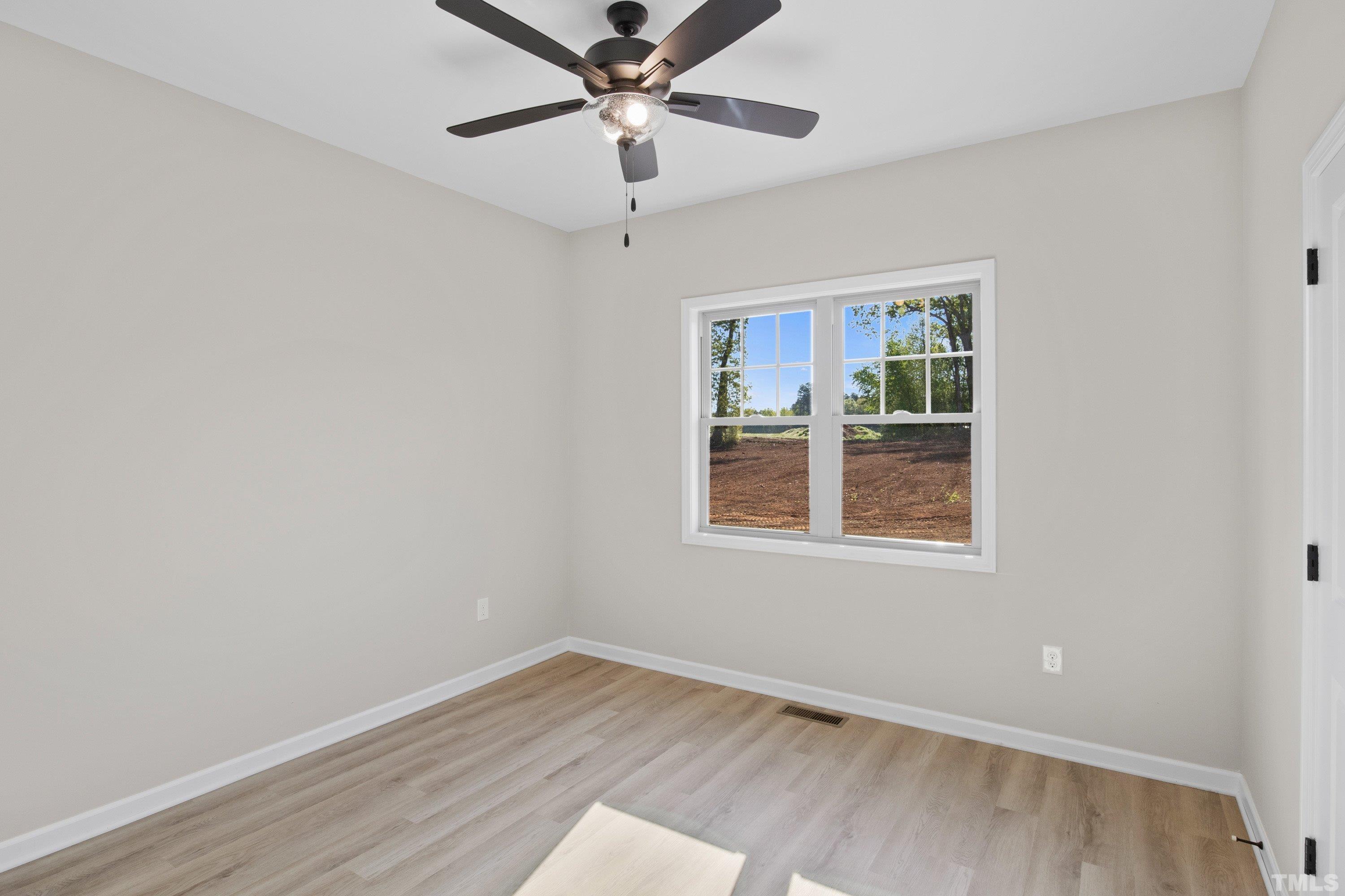 9765 Bear Run Lane Middlesex, NC 27557 - Photo 31 of 38 an empty room with wooden floor fan and windows