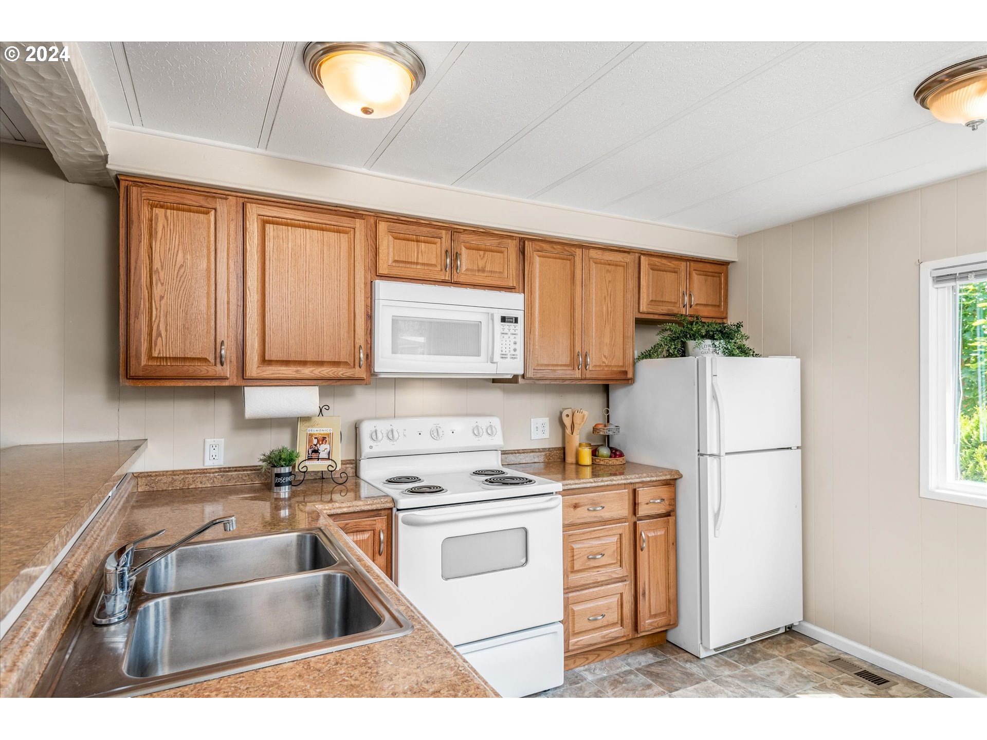 2150 Laura Street, Unit 90 Springfield, OR 97477 - Photo 5 of 18 a kitchen with a refrigerator sink and cabinets