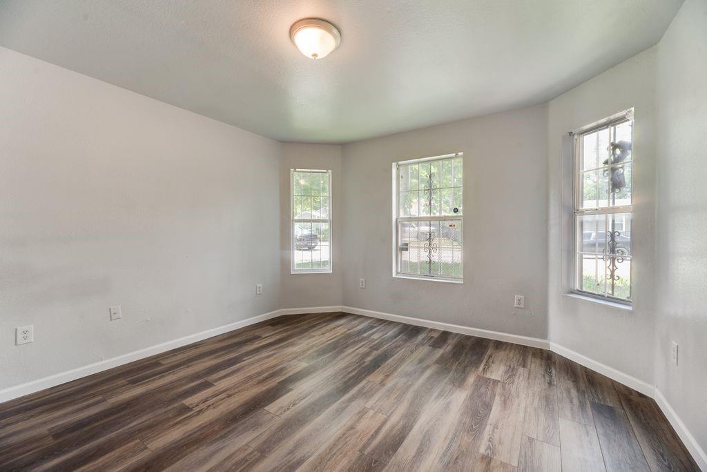 2526 Exeter Avenue Dallas, TX 75216 - Photo 15 of 19 Room featuring wood-finish flooring, light gray walls, and multiple windows