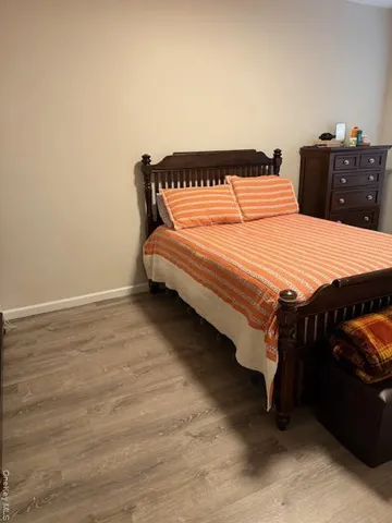 a bedroom with a bed and a lamp on dresser