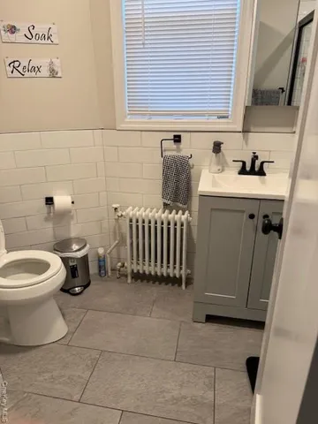 a bathroom with a sink a toilet and a window