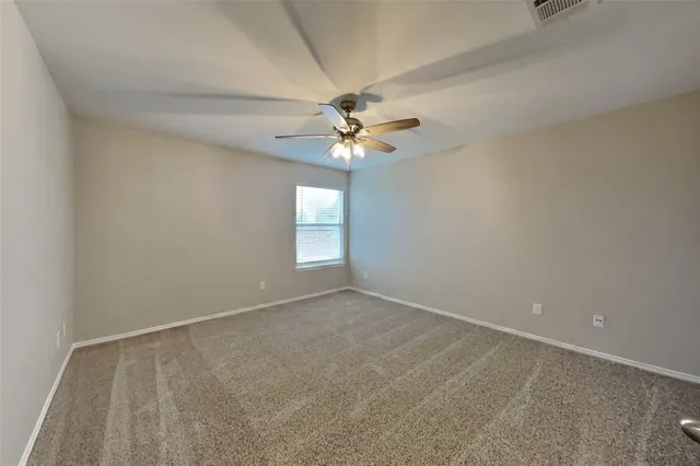 an empty room with windows and chandelier fan