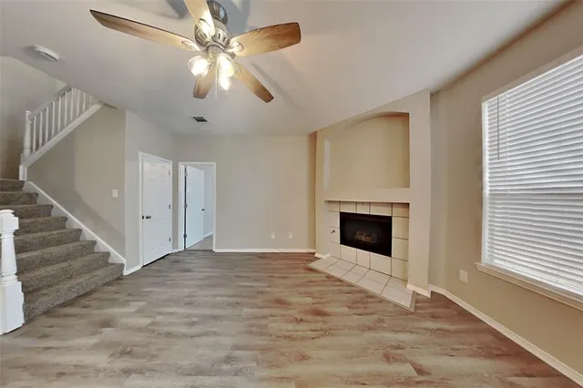 a view of a livingroom with a fireplace chandelier fan and windows