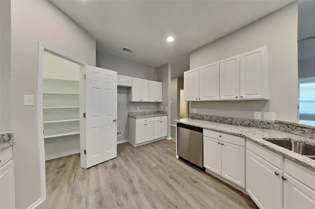 a kitchen with granite countertop white cabinets and white appliances