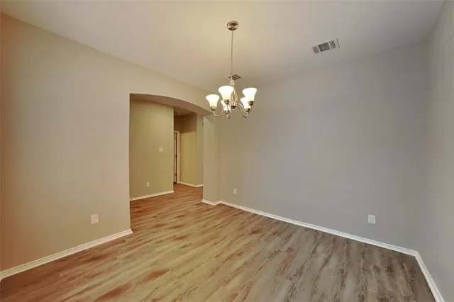 a view of a room with wooden floor and chandelier