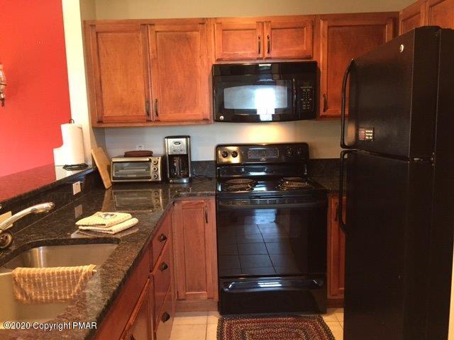 557 Upper Deer Valley Road Tannersville, PA 18372 - Photo 15 of 41 a kitchen with stainless steel appliances granite countertop a stove a refrigerator and a microwave