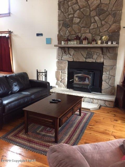 557 Upper Deer Valley Road Tannersville, PA 18372 - Photo 7 of 41 a living room with furniture and a fireplace