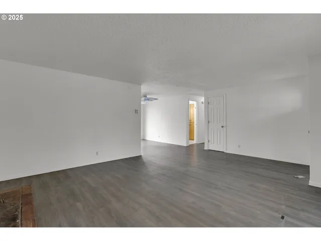 a view of an empty room and wooden floor