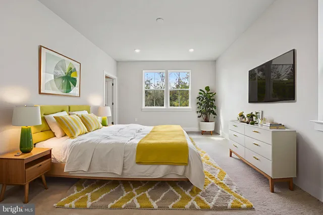 a spacious bedroom with a bed and a flat screen tv