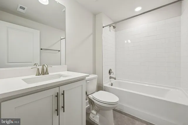 a white toilet and tub sitting next to a bathroom sink