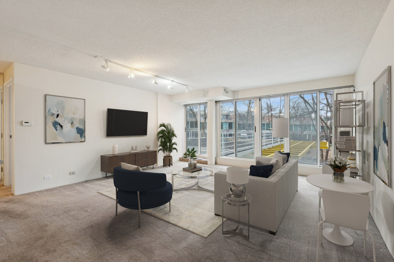 2555 Gross Point Road, Unit 101 Evanston, IL 60201 - Photo 2 of 23 a living room with furniture a flat screen tv and a floor to ceiling window