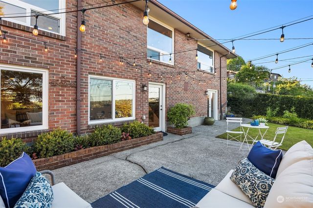 a view of a porch with couches and table and chairs next to yard
