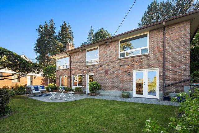 a view of a house with a yard and a tree