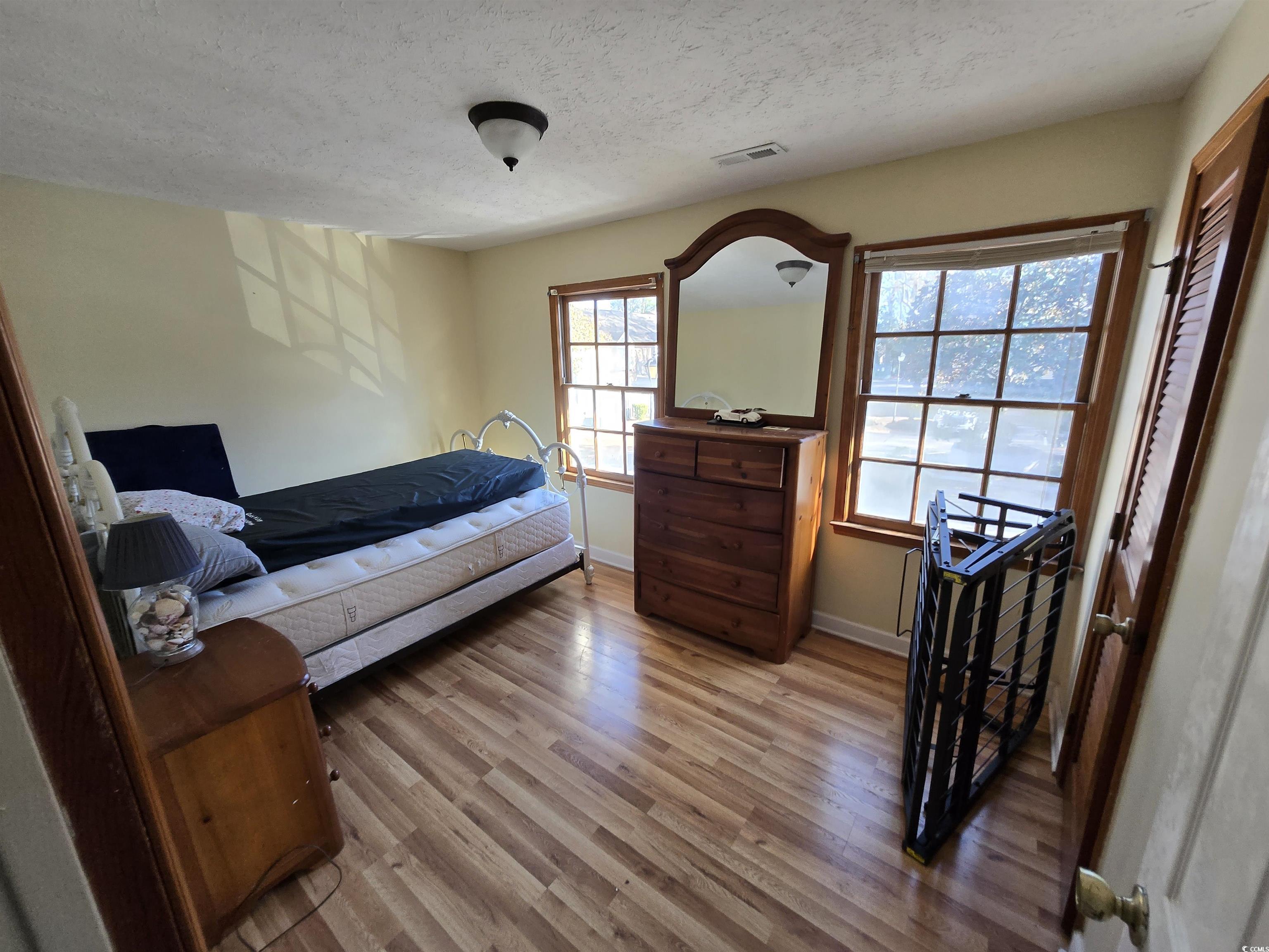 830 44th Avenue North, Unit B4 Myrtle Beach, SC 29577 - Photo 9 of 13 Bedroom with a textured ceiling and light wood-style flooring