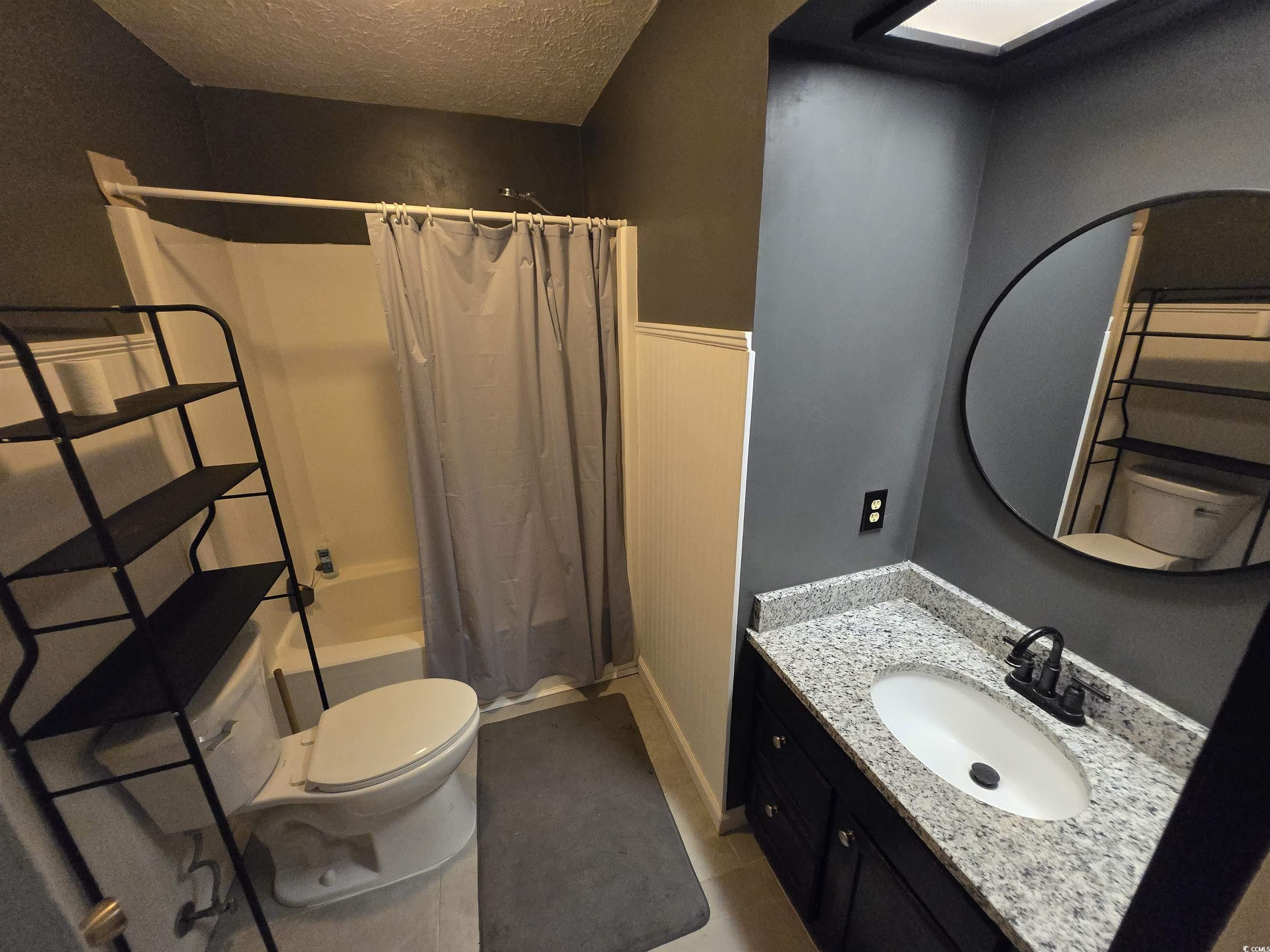 830 44th Avenue North, Unit B4 Myrtle Beach, SC 29577 - Photo 10 of 13 Full bathroom with shower / bath combination with curtain, vanity, and a textured ceiling