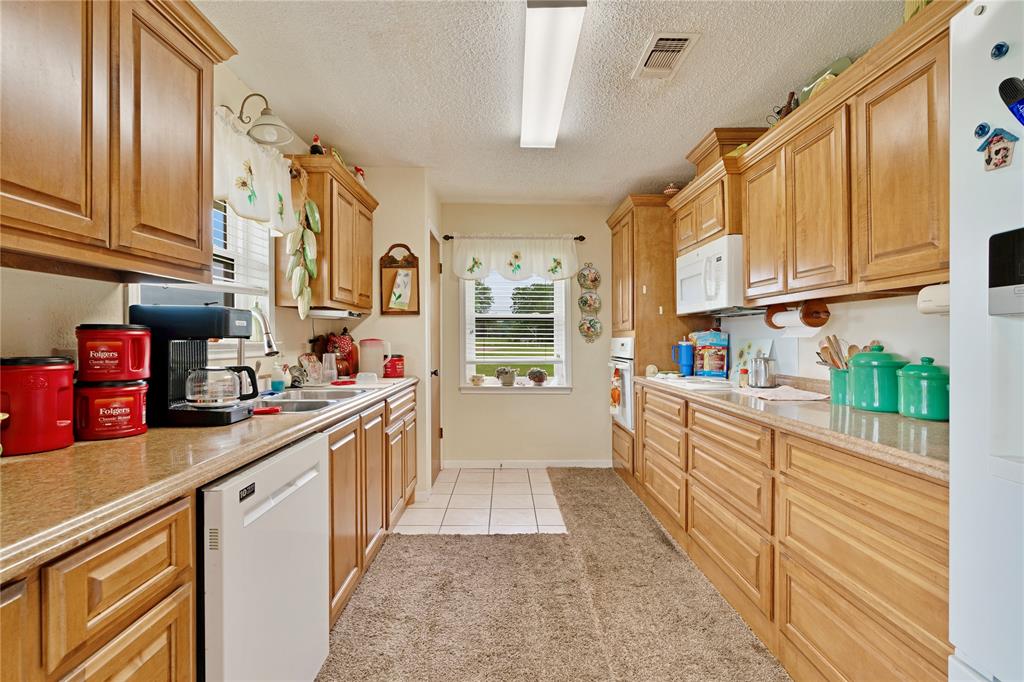 1355 County Road 33100 Sumner, TX 75486 - Photo 26 of 34 a kitchen with stainless steel appliances granite countertop a sink and cabinets