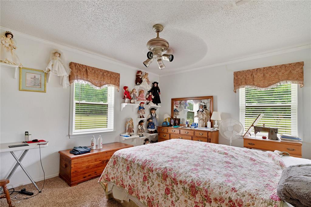 1355 County Road 33100 Sumner, TX 75486 - Photo 30 of 34 a bed room with a bed and a chandelier