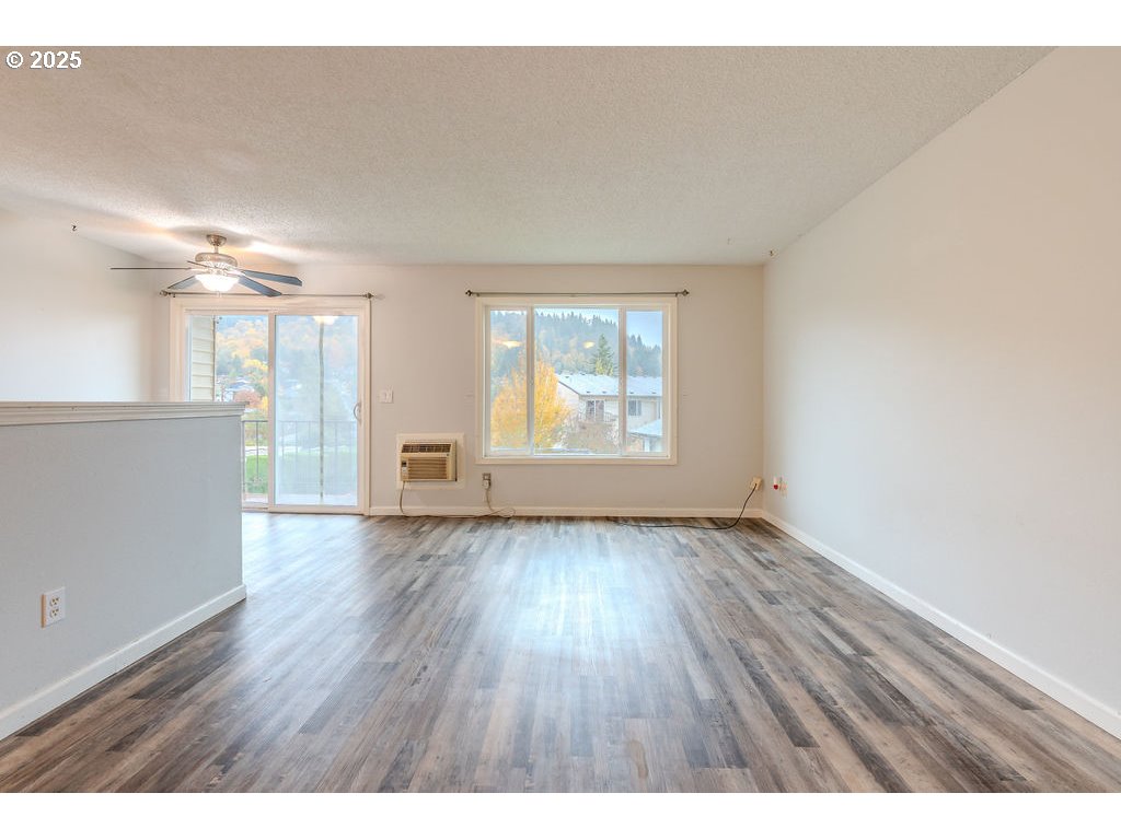 200 Southwest Florence Avenue, Unit D15 Gresham, OR 97080 - Photo 4 of 29 a view of an empty room with wooden floor and a window